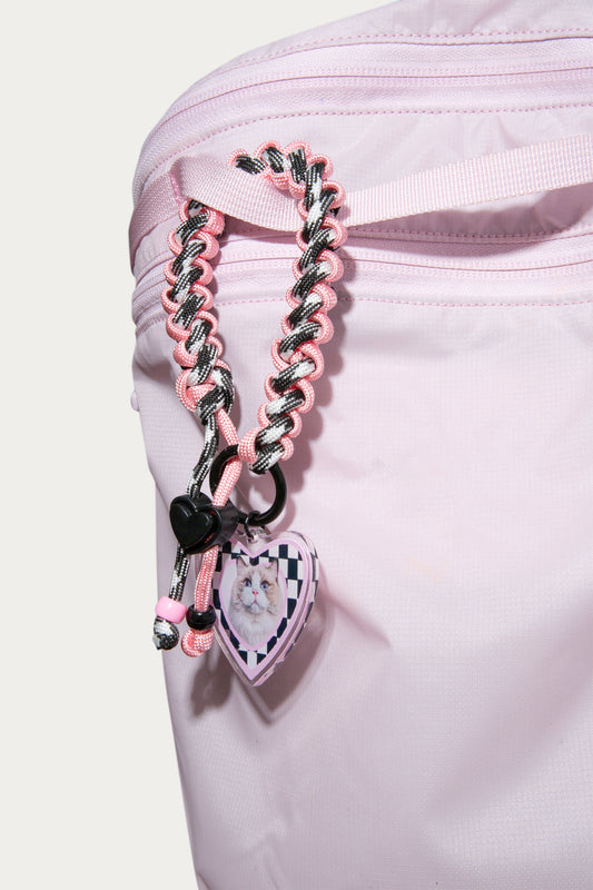 Pink braided strap with heart-shaped charms on a white background