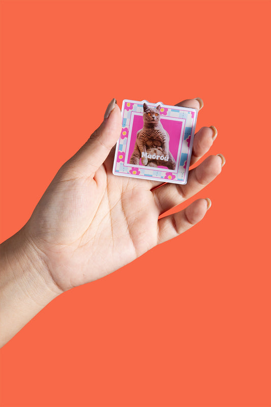 Hand holding a small card with a cat illustration on an orange background