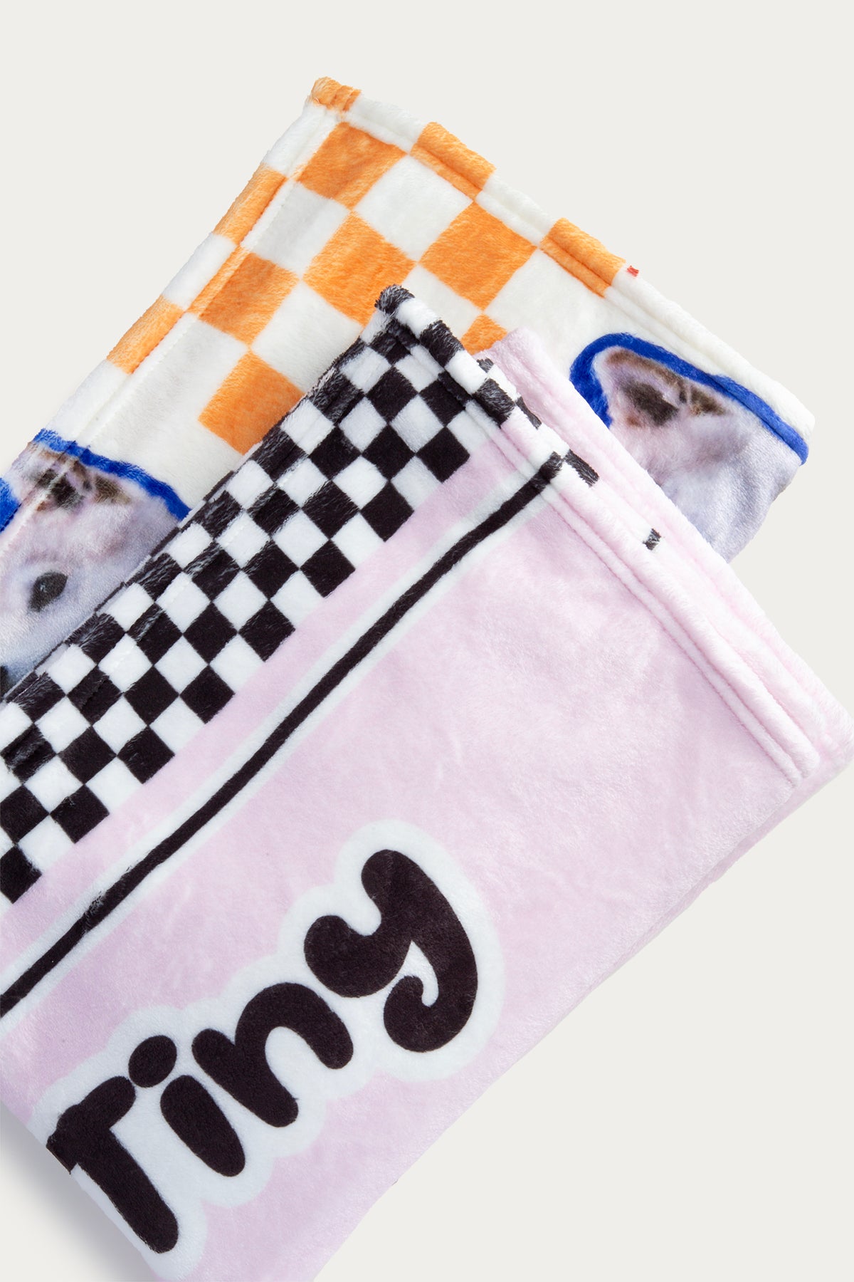 Three dog towels with different patterns and a 'Tiny' towel on a white background