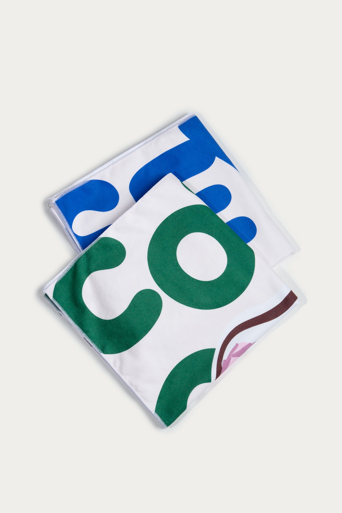 Two square towels with colorful abstract patterns on a white background