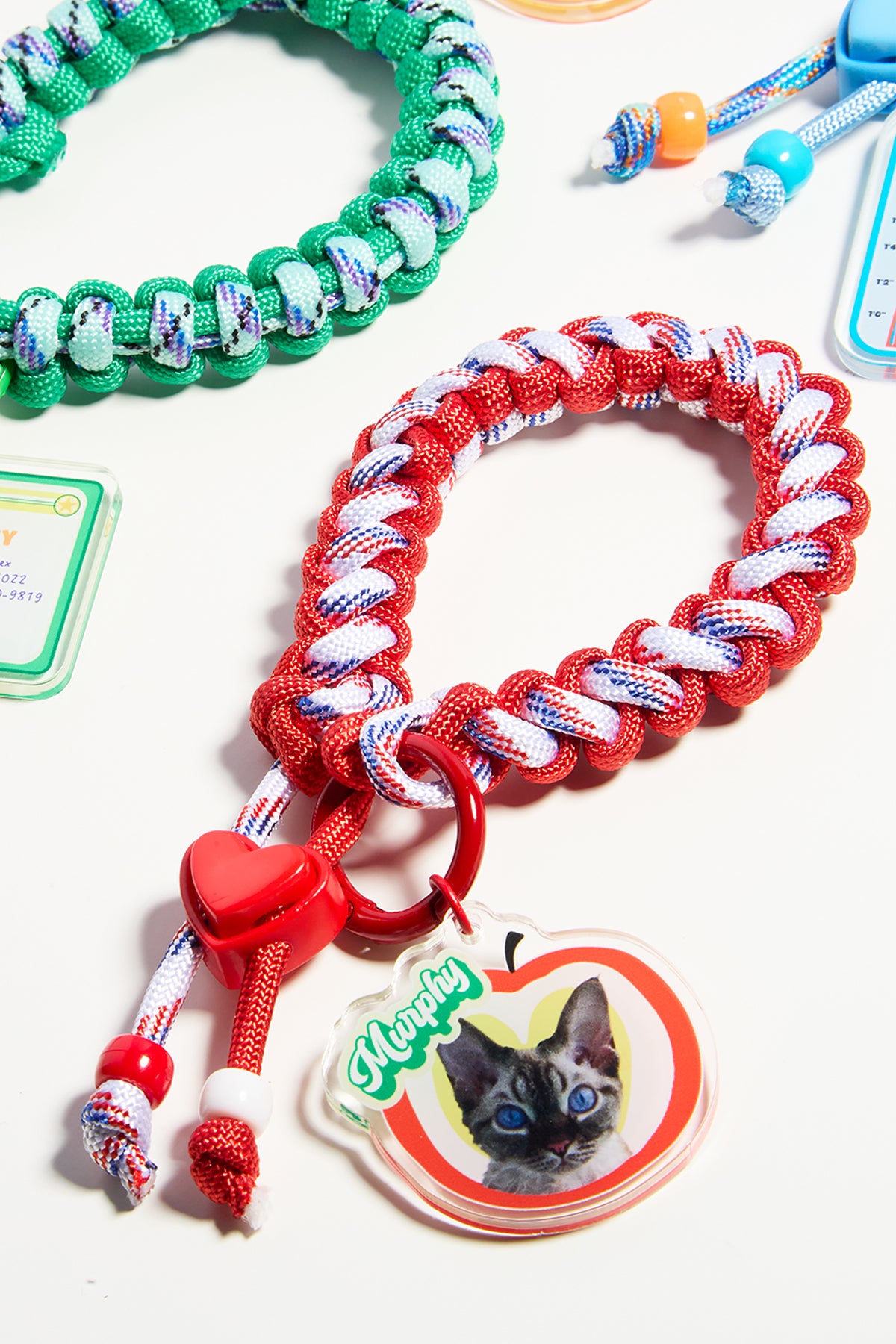 Dog leashes with colorful patterns and a cat-themed tag on a white background