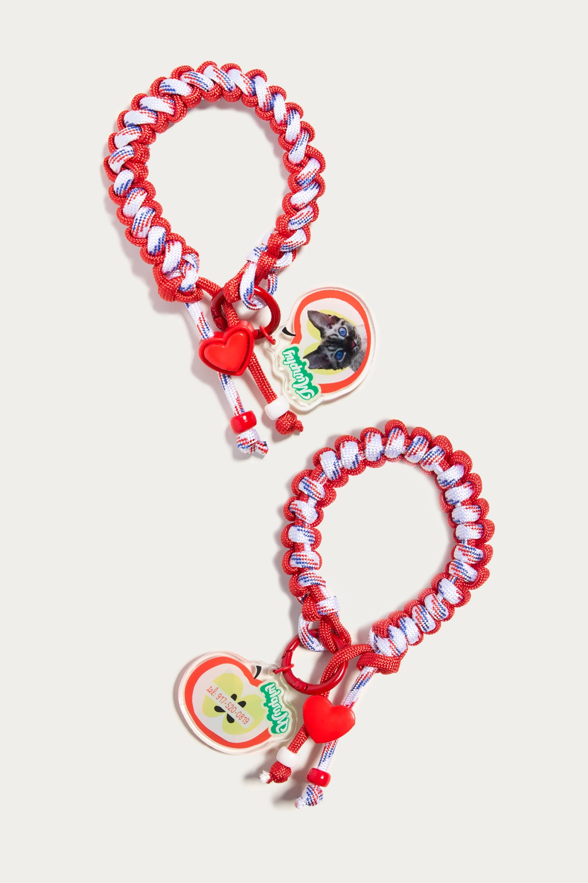 Two red and white braided dog leashes with cartoon character charms on a light gray background