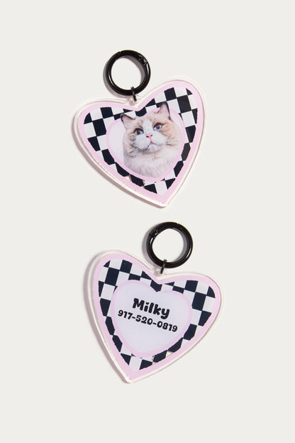 Heart-shaped pet tags with a checkered border and photo of a cat on a white background