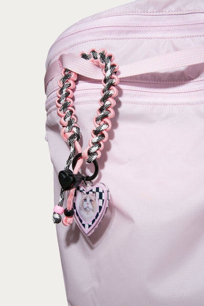 Pink braided strap with heart-shaped charms on a white background