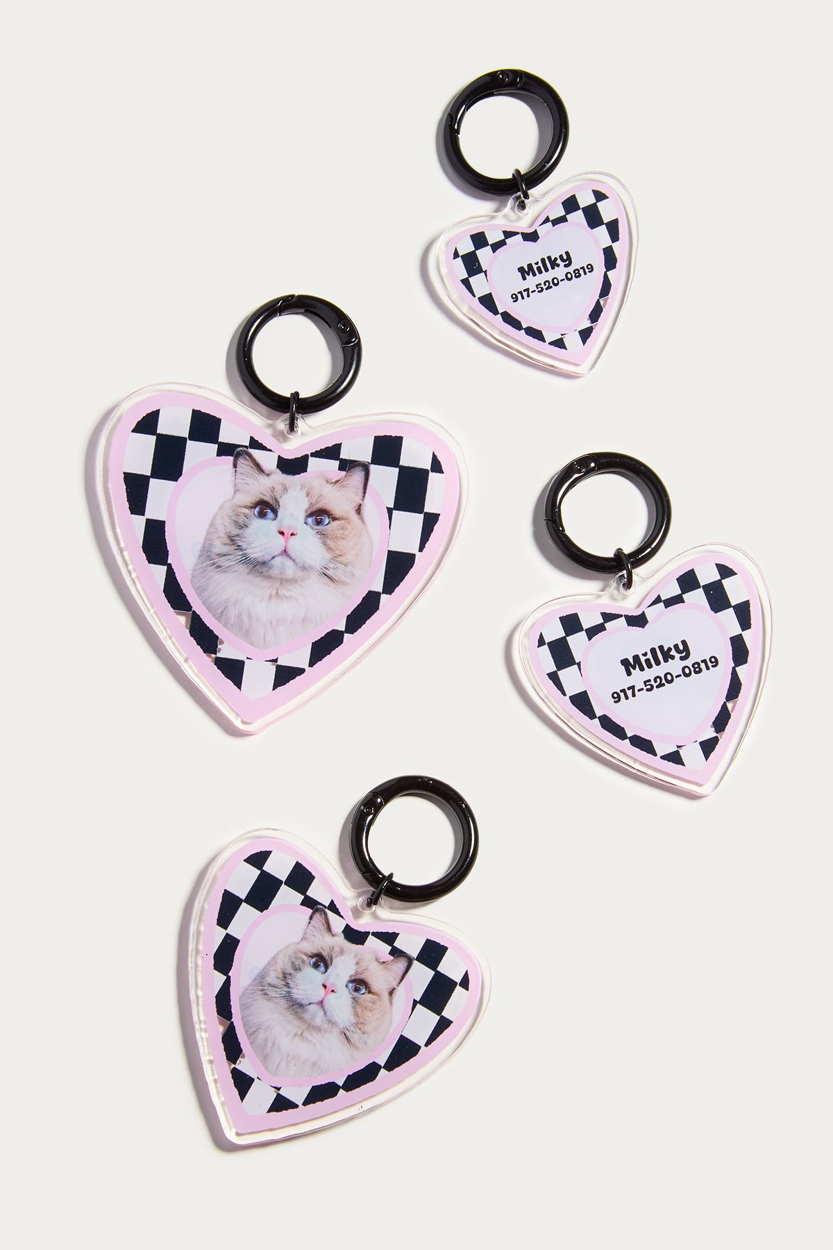 Heart-shaped pet tags with checkered border and cat photo on a white background