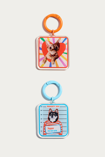 Two keychains with dog illustrations on a white background