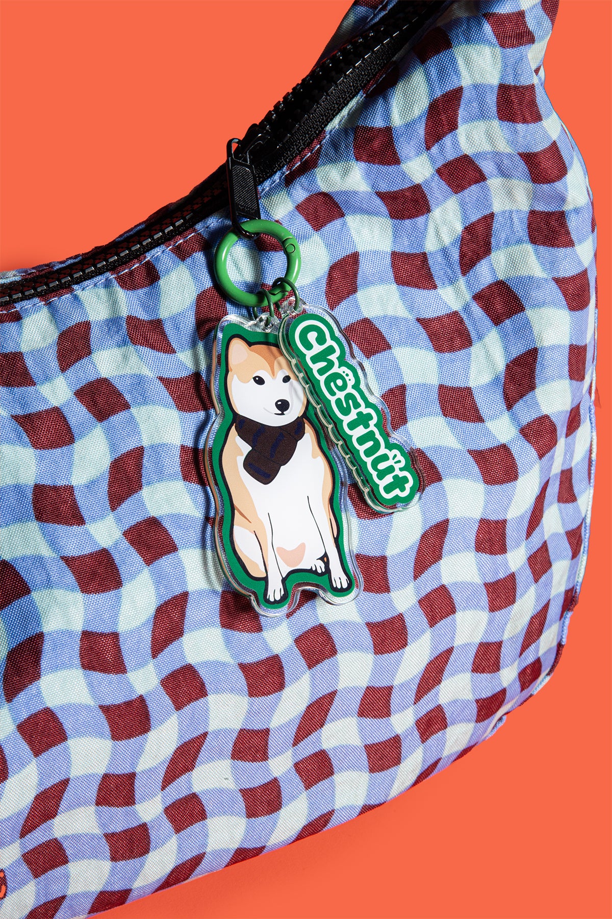Checkered bag with a dog-themed keychain on an orange background