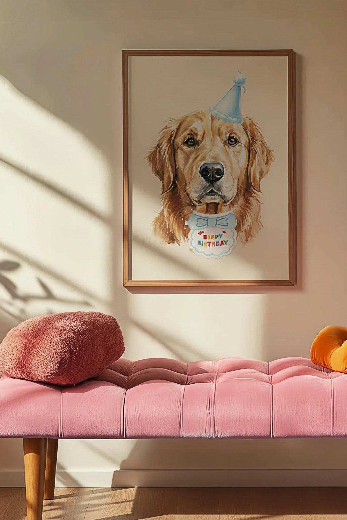 Framed artwork of a dog with a birthday hat on a wall above a pink bench.
