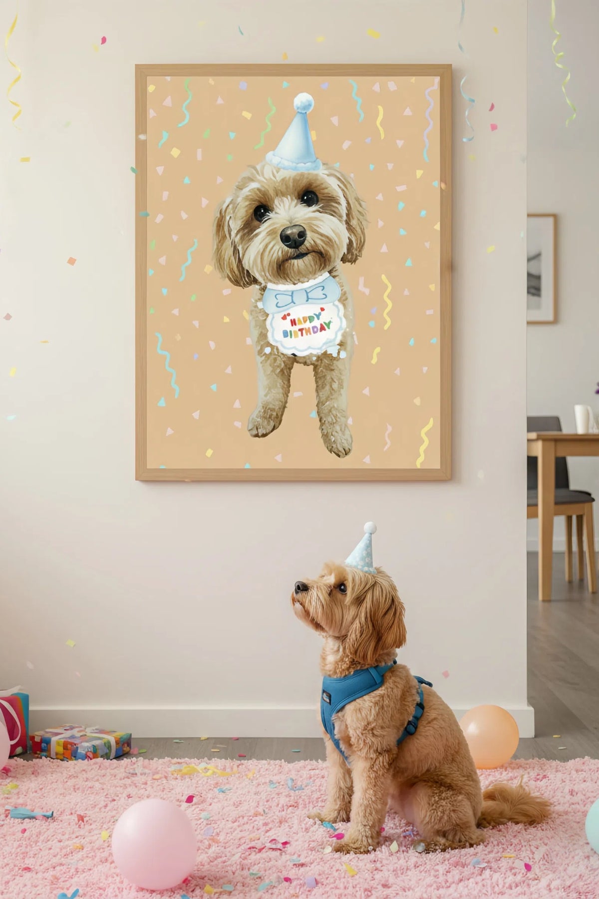 Dog wearing a party hat in front of a framed picture of a dog with a birthday hat and banner.
