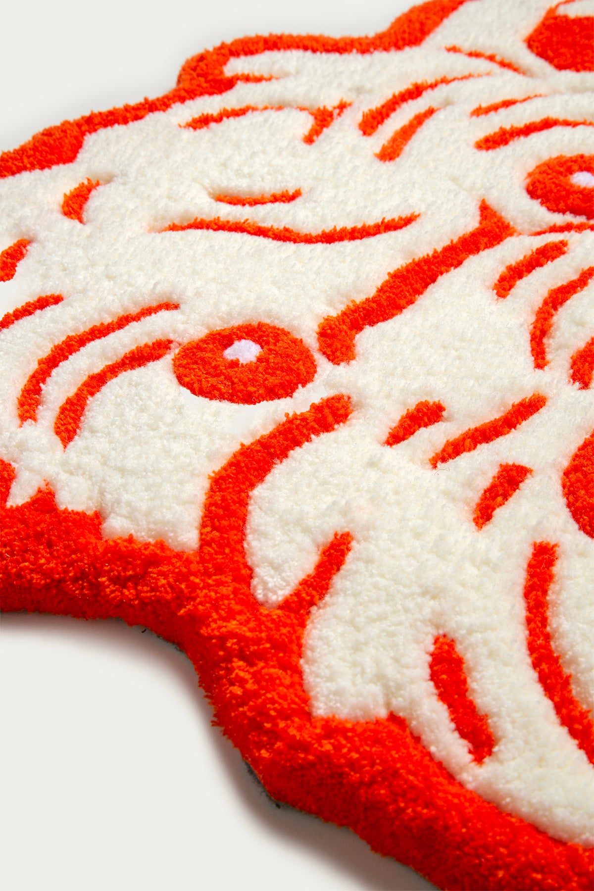 Close-up of a red and white patterned rug on a white background